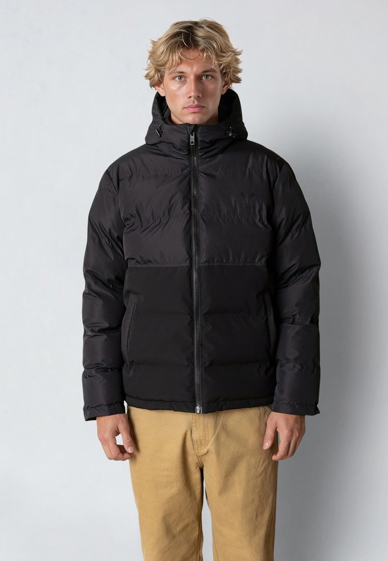 Svart puffjacka med dragkedja framtill och huva. Har quiltad textur, justerbara snoddar och en enfärgad design utan mönster.