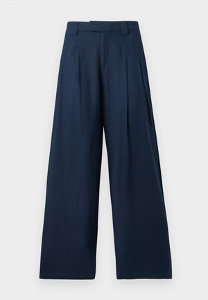 Pantalon large bleu marine taille haute, avec passants pour ceinture, plis à l'avant et fermeture frontale dissimulée.
