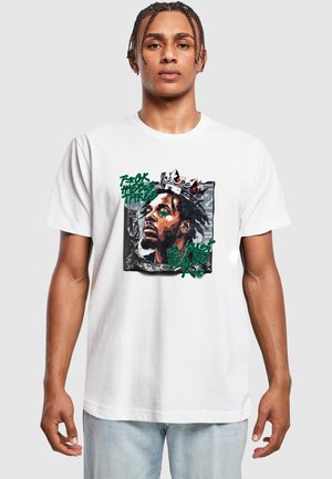 Hvid bomulds t-shirt med et grafisk print af en mand med en krone, akkompagneret af grøn og sort tekst samt en tekstureret baggrund.