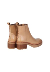 Stivaletti alla caviglia in pelle beige con tacco marrone texturizzato, cuciture rosse a contrasto e linguette superiori per una facile calzata.