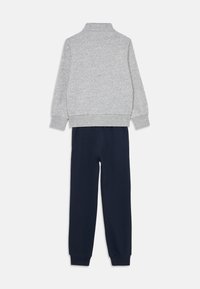 Grijze sweatshirt met hoge kraag en ribgebreide boorden, gecombineerd met marineblauwe joggerpants met een elastische tailleband en ribgebreide enkelboorden.