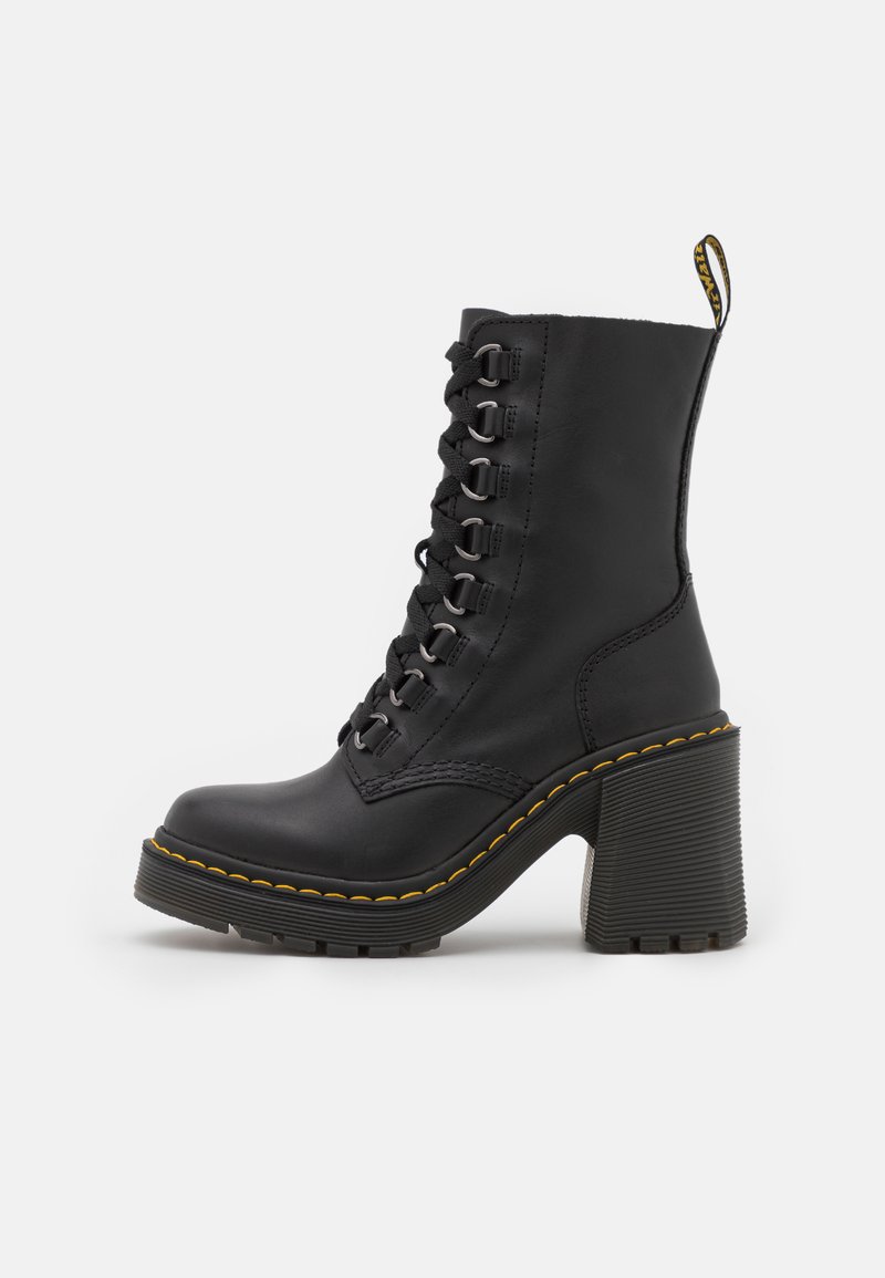 Stivaletto in pelle nera con tacco spesso, dotato di occhielli argentati e lacci neri, accentuato da cuciture gialle lungo la suola.