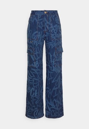 Tummansiniset leveälahkeiset denim-housut vaaleansinisin graffiti-kuvioin, edessä läpälliset taskut ja kultainen nappikiinnitys.
