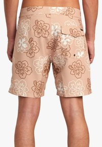 Beige badshorts med vitt och brunt hibiskusblommönster, med en bakficka och ett mjukt, lätt tyg.