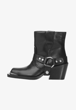 Sort læderankelstøvle med spids tå, metallisk spænde og en kraftig hæl. Glat tekstur med dekorative metalaccenter.