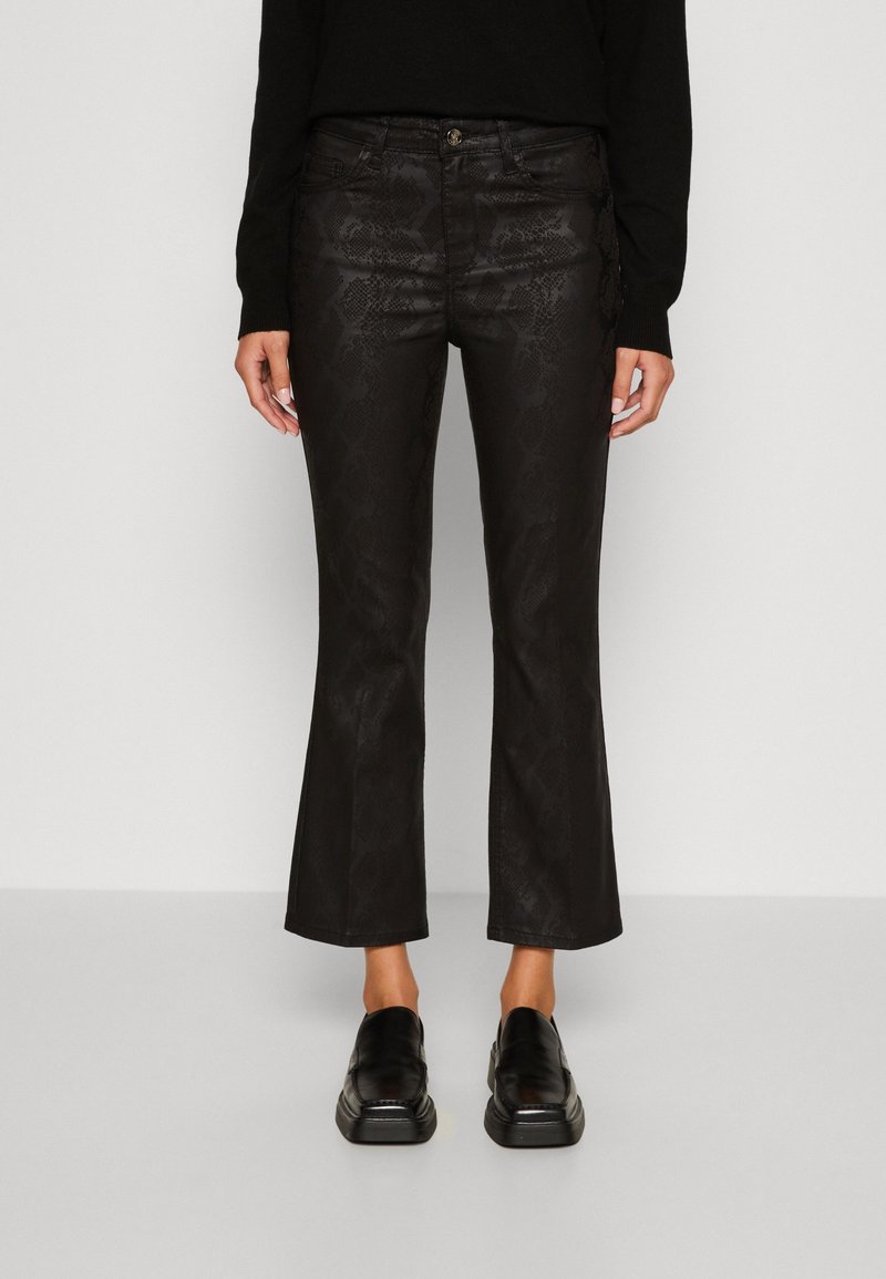 Svarta utsvängda byxor med orm mönster, med en framknapp, fem fickor och en slät yta. Bärs med svarta skor.