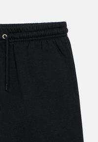 Schwarze Jogginghose mit elastischem Bund und Kordelzug. Weicher Stoff, lässige Passform, mit Seitentaschen und minimalen Nähten.