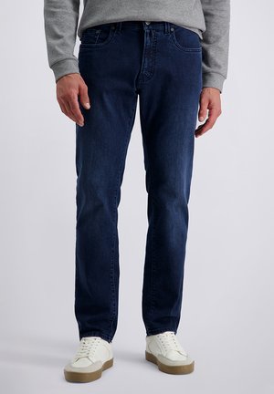 Donkerblauwe denim jeans met een rechte pijp, voorzien van steekzakken en een klassieke knoop- en ritssluiting, gecombineerd met witte sneakers.