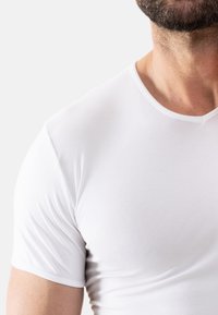 White short-sleeve T-shirt made of smooth cotton fabric, featuring a round neckline and a fitted shape, no visible logos or patterns.