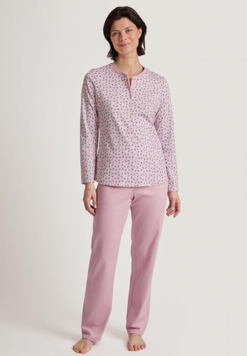 Rosa Langarm-Schlafanzugoberteil mit floralem Druck und Henley-Ausschnitt, kombiniert mit einfarbigen rosa Hosen, beide aus einem weichen Stoff.