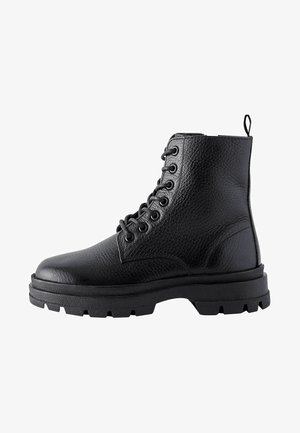 Bottines en cuir noir avec une finition texturée, bout rond, lacets à l'avant et semelle en caoutchouc épaisse avec un profond profil pour une meilleure traction.