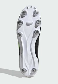 Zwarte voetbalschoen zool met een witte plastic plaat, zes metalen noppen en een gestructureerd patroon. Bevat een groene accen aan de zijkant.