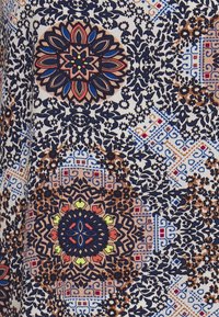 Tejido estampado que presenta un diseño floral y geométrico en azul marino, crema y marrón, con acentos brillantes, textura suave y detalles intrincados.