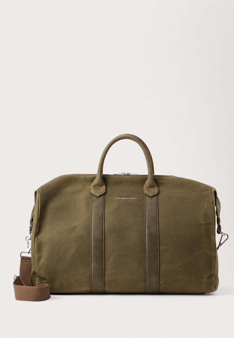 Bolsa de viaje verde oliva con asas dobles en la parte superior y correa para el hombro ajustable. Material de tela con acentos de cuero y cierre de cremallera.