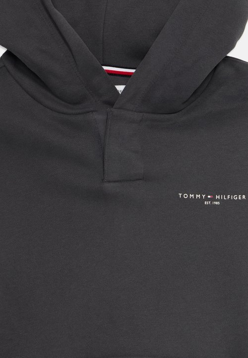 Dunkelgrauer Kapuzenpullover mit einer Kängurutasche. Er hat ein kleines weißes "TOMMY HILFIGER"-Logo und rot-weiße und blaue Abschlüsse am Ausschnitt.