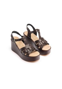 Brown leather platform sandals featuring woven straps, a tan footbed, and adjustable ankle straps for a secure fit.