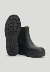 Rubber ankle boots in black with a textured sole. Features a green accent at the back and a smooth upper design. Durable and waterproof.