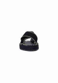 Zwarte espadrille sandaal met kruisbanden, textielstof en contrasterende witte stiksels. Platte zool met geweven randafwerking.