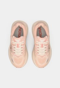 Αθλητικά παπούτσια σε ανοιχτό ροζ χρώμα με αναπνεύσιμη επάνω επιφάνεια από διχτυωτό υλικό, στρογγυλή μύτη, παχύ πάτο και διακριτικές γκρίζες λεπτομέρειες. Διαθέτουν επίπεδους κορδόνες και λογότυπο.