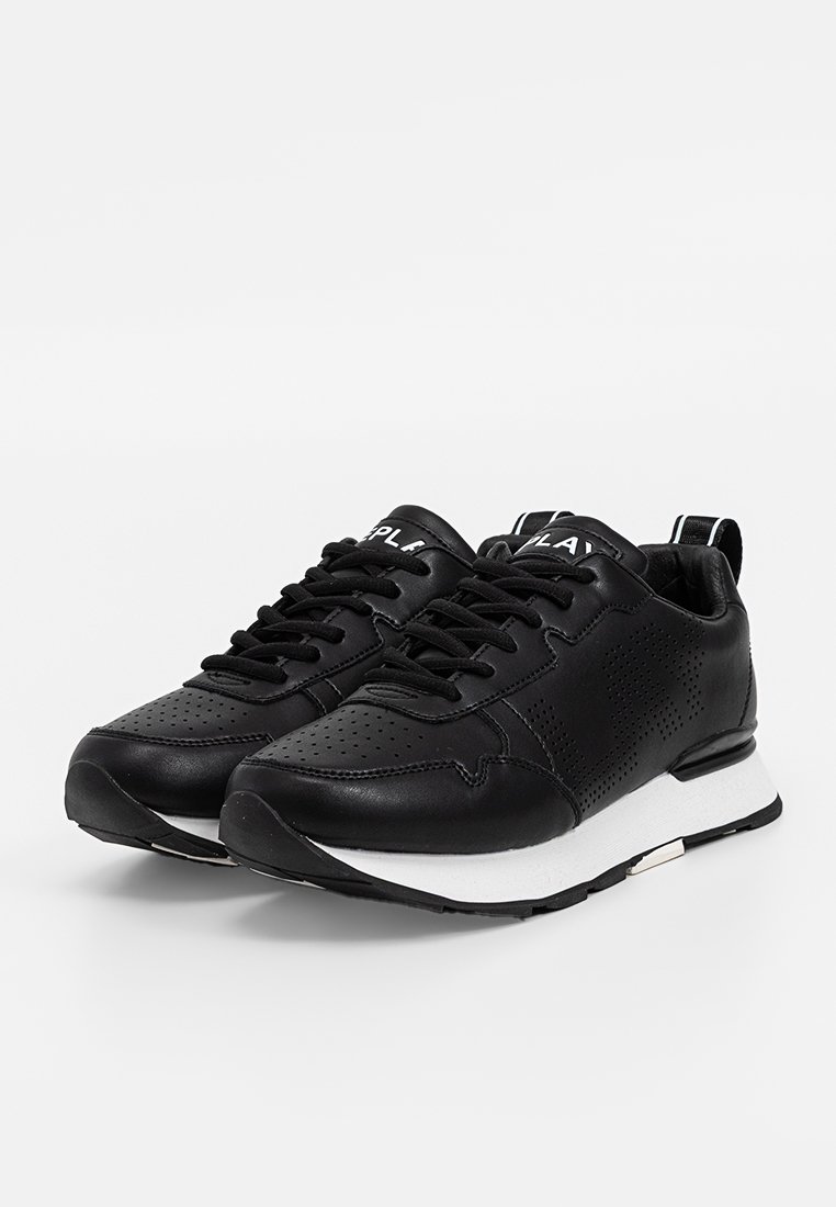 Un paio di sneaker in pelle nera con dettagli perforati, lacci neri e suole bianche, angolati a sinistra su uno sfondo bianco semplice.