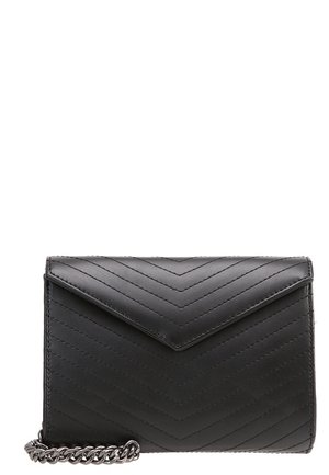 Schwarze gesteppte Leder-Clutch mit V-Überschlag und silberner Kettenriemen, sichtbar in der unteren linken Ecke.