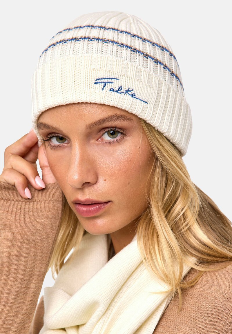 Berretto in maglia bianco con texture a coste, caratterizzato da strisce orizzontali blu e marroni, e con ricamo blu della scritta "Falke" sulla parte frontale.