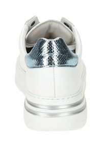 White sneaker with a textured silver snake-print heel, silver accent stripe, and smooth surface. Features a padded collar and lacing system.