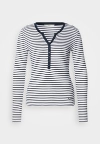 Μπλούζα με μακριά μανίκια σε λευκό και ναυτικό μπλε ριγέ. Διαθέτει V-λαιμόκοψη, λεπτομέρεια με κουμπιά και ριπ υφή με λογότυπο στο κάτω μέρος.