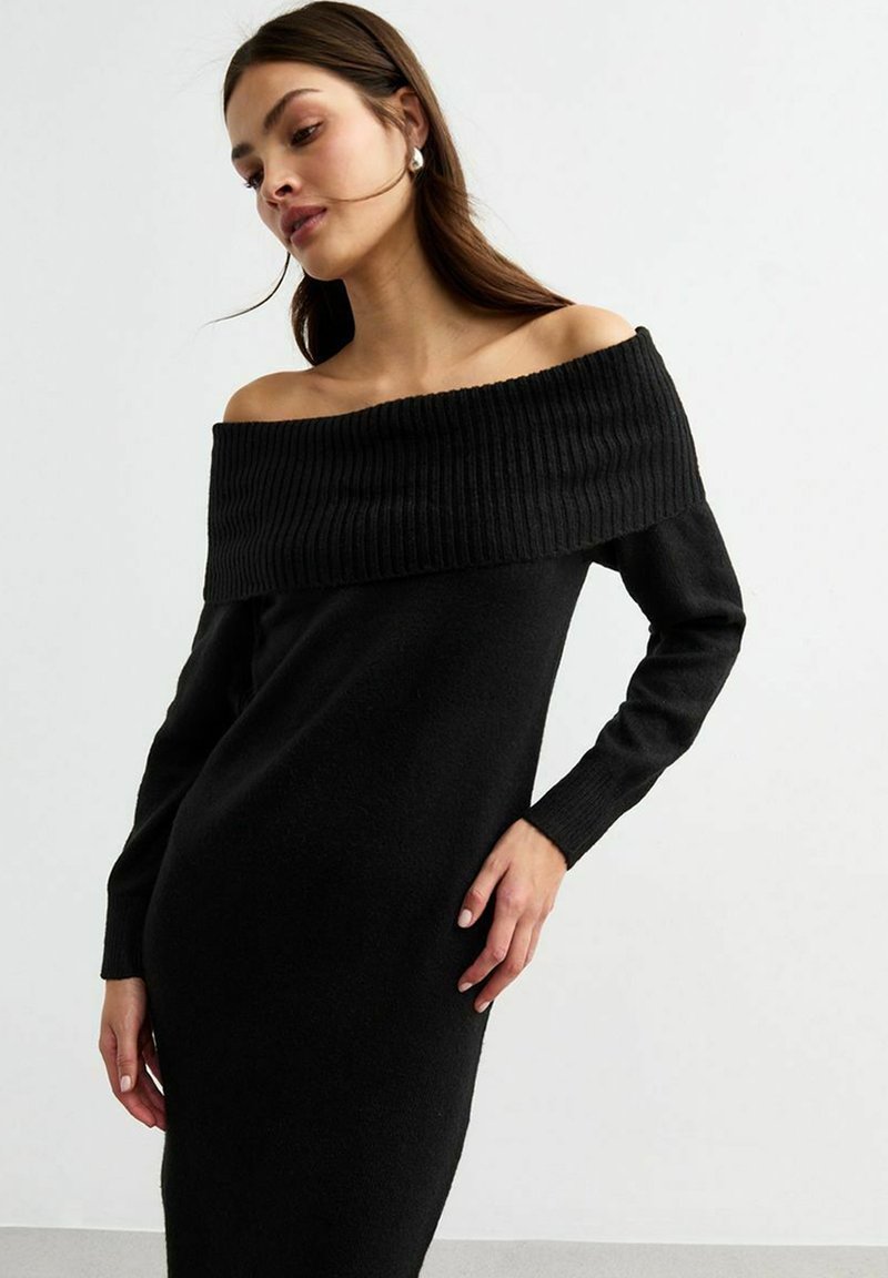 Abito nero off-the-shoulder in morbido tessuto a maglia, con scollatura a coste e maniche lunghe, dal taglio aderente.