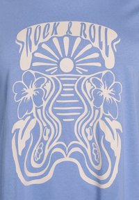 T-shirt bleu clair avec un grand design graphique blanc "Rock & Roll", un soleil et des accents floraux, fabriqué en coton doux.