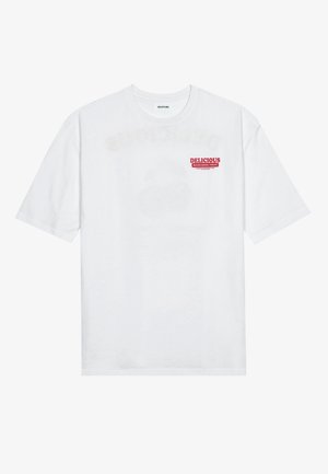 T-shirt en coton blanc avec manches courtes, col rond, et un motif imprimé rouge indiquant "FRUIT DÉLICIEUX ET RAFRAÎCHISSANT".
