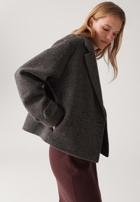 Koolgrijze wollen blend jas met een boxy silhoutte, grote knopen en zijzakken. Voorzien van een geknipte kraag en lichte schouderpadding.