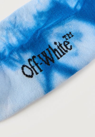 Φωτεινό γαλάζιο ύφασμα με στάμπα "OFF-WHITE™" σε μαύρο, που δείχνει υφή πλεξίματος και λεπτομέρειες σκίασης.