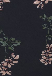 Mörk tyg med spridda rosa och gröna blommönster som innehåller små blommor och bladstammar.