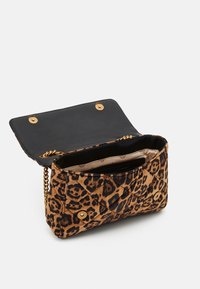 Bolso de mano con estampado de leopardo y textura acolchada, interior negro, herrajes dorados y correa de cadena. Se abre con un cierre magnético.
