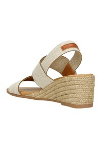 Tan wedge sandal with woven fabric upper and exposed heel. Features crisscross straps and a braided jute-textured sole.