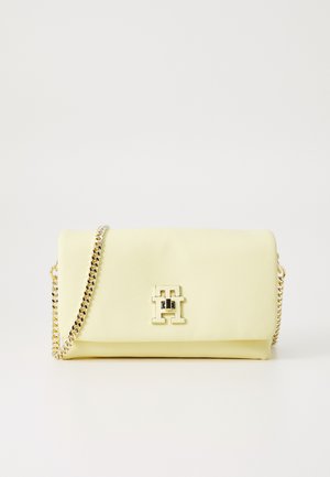 Żółta torebka crossbody z sztucznej skóry z złotym łańcuchem oraz przednim akcentem z logo. Gładka tekstura i kompaktowy prostokątny kształt.