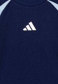 Navy blue T-shirt made of cotton, featuring light blue raglan sleeves and a white Adidas logo on the front.