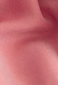 Tissu texturé en rose doux, présentant un motif fin côtelé. Le matériau semble lisse avec un léger éclat, drapant gracieusement.