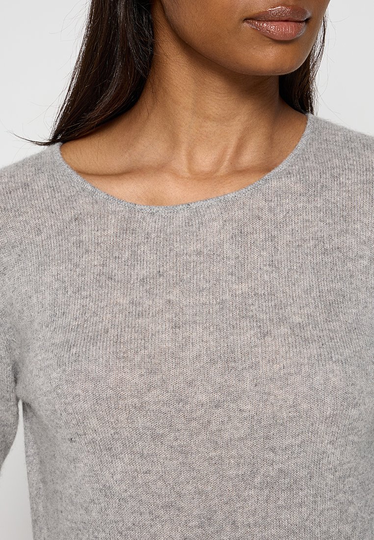 Maglione grigio chiaro in maglia con scollo rotondo, texture morbida e leggermente melangiata. Nessun hardware o dettaglio visibile.