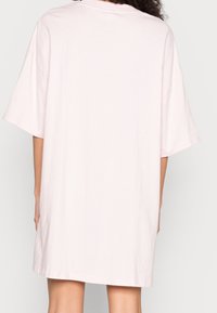 Sukienka-tunika w rozmiarze oversize z miękkiej, jasnoróżowej bawełny, z krótkimi rękawami i luźnym krojem oraz prostym okrągłym dekoltem.