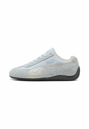 Baskets basses pour homme Puma en daim gris clair et blanc cassé avec semelle noire texturée, logo Puma sur le côté et fermeture lacée.