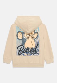 Sudadera beige con un gráfico de un mono de dibujos animados en azul y negro, con el texto "Bored of directors" debajo, sobre un fondo a rayas.