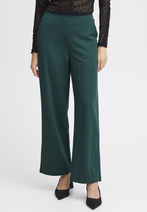 Dark green wide-leg pants made from smooth fabric, featuring a high waistband and a straight silhouette, paired with black heels.