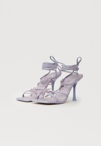 Sandales à talons hauts violettes à lanières, ornées de fleurs, avec des accents en strass et une finition brillante. bout carré.