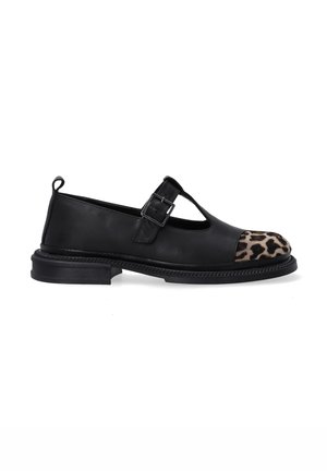 Black leather shoe with a leopard print cap toe, featuring a T-strap and buckle detail, flat sole, and textured stitching.