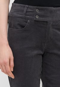 Grå corduroy bukser med klassisk fem-lomme design, to-knapp lukking og vertikal ribbet tekstur.