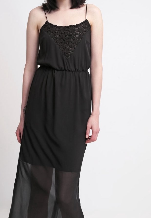 Černé šaty s nastavitelnými tenkými ramínky, krajkovými detaily na výstřihu, elastickým pasem a průsvitným ženským detailem na spodním okraji.