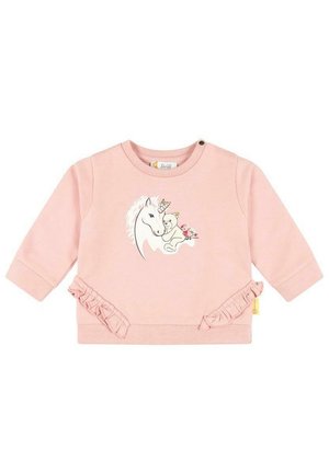 Lyserød langærmet babytrøje med flæsedetaljer og et tryk af en enhjørning, en bamse og en fugl iført festhatte på forsiden.