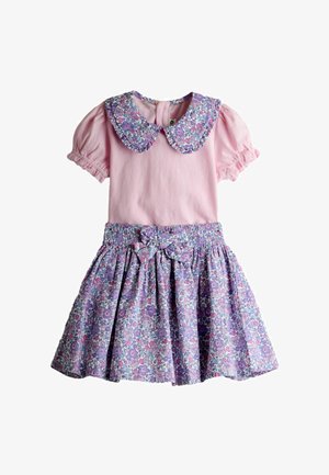 Ružičasta haljina kratkih rukava s naboranim rukavima, ljubičasta Peter Pan ovratnik s cvjetnim uzorkom i odgovarajuća cvjetna suknja s mašnom u struku.